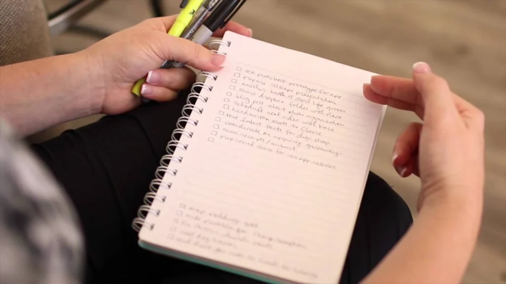person writing travel priorities on paper