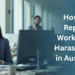 Professional woman in an office speaking on the phone, with headline text “How to Report Workplace Harassment in Australia” displayed on the right.