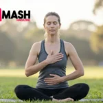 Australian woman demonstrating fast breathing stress relief technique in peaceful park setting with hands on chest and belly